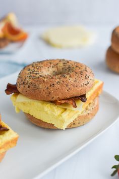 a bagel sandwich with eggs and bacon on it