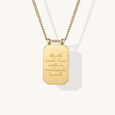 a gold dog tag necklace with the words i am the storm written in cursive writing