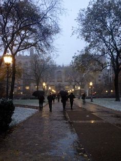 people walking down a sidewalk in the rain