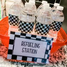 bottles of refueling station sitting on top of a counter next to a sign