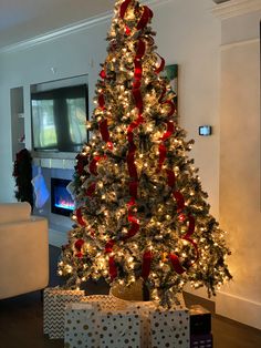 a white christmas tree with red and gold bows