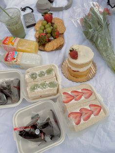 there are many desserts on the table with fruit and snacks in plastic trays