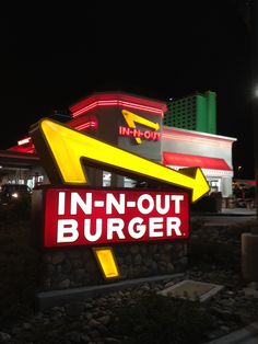 the neon sign for in - n - out burgerr is lit up at night