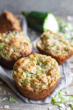 three zucchini muffins sitting on top of a cloth