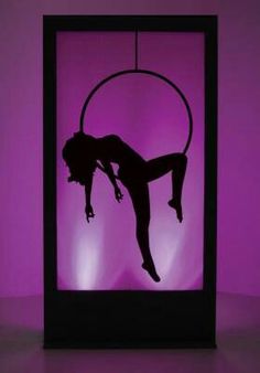 the silhouette of a woman is projected in front of a purple background