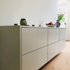 a white cabinet with bowls and vases on top