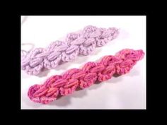 two crocheted hair ties on a white table with one pink and one purple