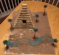 a cake made to look like a pyramid with palm trees in the sand and water