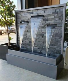 an outdoor fountain with three water jets in it