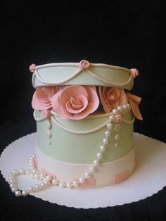 a cake with flowers and pearls on top