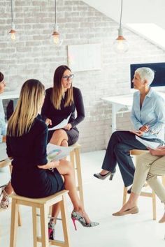 four women sitting in chairs talking to each other