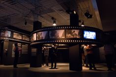 people are standing around in front of some movie reels at the movies and television museum