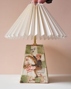 a lamp with a horse and rider on it is being held by a person's hand