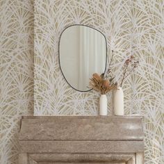 a fire place sitting next to a mirror on top of a mantle in front of a wall