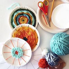 paper plates with yarn and scissors on them