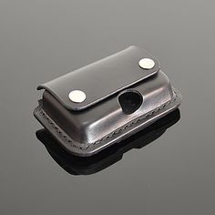 a cell phone case sitting on top of a black surface with two holes in it