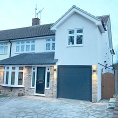 a large white house with black garage doors