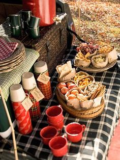 an outdoor picnic with food and drinks on the table in front of it, ready to be eaten