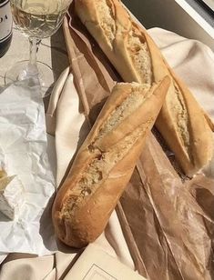 two loaves of bread sitting next to a glass of wine