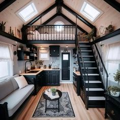 a living room filled with furniture and a stair case next to a kitchen counter top