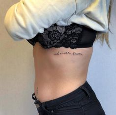 a woman's stomach with the word love tattooed on her lower back and side