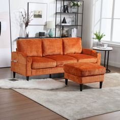 an orange couch and ottoman in a living room