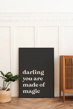 a poster with the words daring you are made of magic on it next to a plant