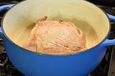 a piece of meat in a blue pot on the stove