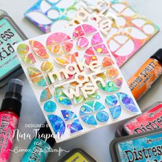 some crafting supplies sitting on top of a white table with markers and ink bottles