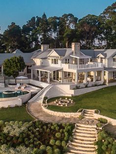 an aerial view of a large white house with stairs leading up to the front door