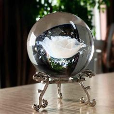 a glass ball with a flower in it on a table