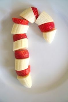 two bananas and strawberries are arranged in the shape of a candy cane