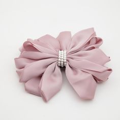 a large pink bow with pearls on it