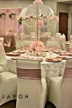 the tables are set up for a wedding reception with pink and white flowers on them