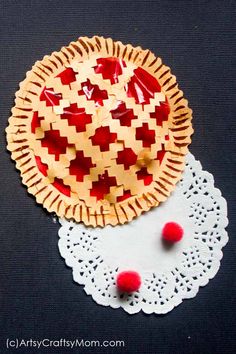 a pie on a doily next to a paper doily with red and white designs