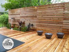 a wooden deck with three planters on it and a fence in the back ground