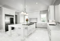 a large kitchen with white cabinets and marble counter tops, along with stainless steel appliances