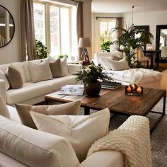 a living room filled with white furniture and lots of pillows on top of it's couches