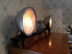 an old fashioned desk lamp on top of a wooden table