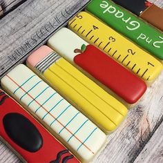 an assortment of different shaped cookies sitting on top of a wooden table next to rulers