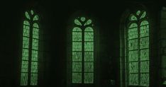 three windows with green light shining through them