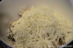 shredded cheese in a white bowl on top of a counter