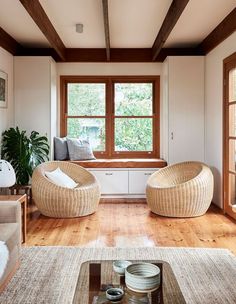 a living room filled with lots of furniture and a big window in the wall behind it