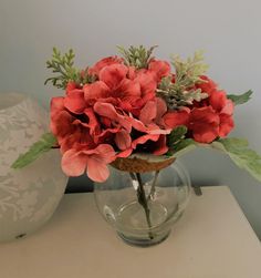 a vase filled with red flowers on top of a table