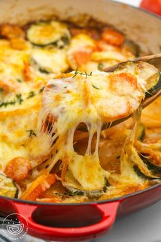 a red pan filled with cheesy vegetable casserole