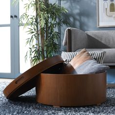 a living room scene with focus on the foot rest and pillows in the centerpiece