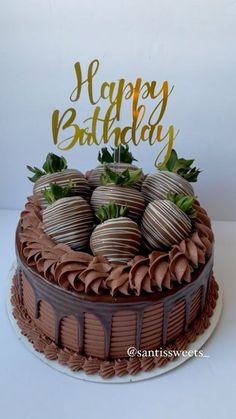 a birthday cake with chocolate covered strawberries on top