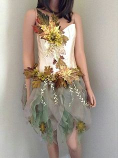 a mannequin is dressed up with leaves and flowers