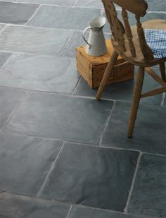 a wooden chair sitting on top of a stone floor