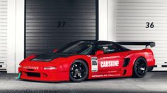 a red sports car parked in front of a garage door